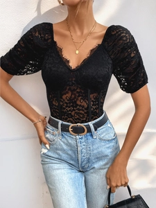 Close-up of black lace bodysuit with V-neckline, puff sleeves, and boning detail