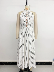 Détail d'une robe dos nu blanche à pois avec quatre nœuds décoratifs sur le devant
