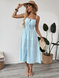 Détail de la robe midi à rayures bleues avec taille smockée et boutonnage sur le buste