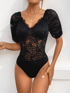 Detail of black lace bodysuit featuring vertical boning and delicate eyelash lace trim