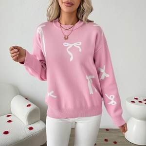 Pink crew neck knit sweater with white bow patterns and ribbed cuffs for women