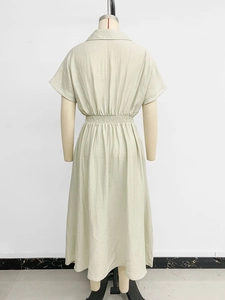 Detail view of the light green cotton-linen dress featuring elastic waist and A-line hem