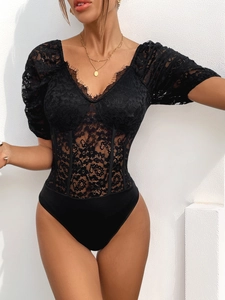 Detail of black lace bodysuit featuring eyelash lace trim and sheer corset boning detail