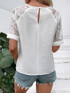 Rear view of white shirt showing delicate lace patchwork and keyhole back detail