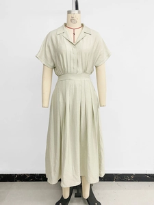Detail of light green midi shirt dress with lapel collar and pleated waist design