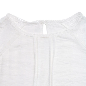 Detailed view of the round neckline with white lace trim and eyelet embroidery details