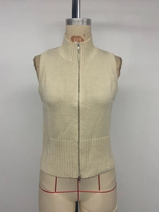 Detail of cream white sleeveless knitted cardigan with vertical ribbed texture and zipper