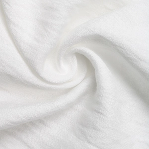 Close-up of white crinkle fabric texture showing delicate lace detailing and soft fibers