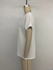 Detail view of white lace patchwork waffle knit top featuring a textured loose fit design