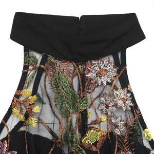 Detail showing colorful floral embroidery on black mesh fabric with lace halter neckline