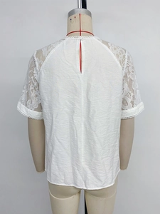 Detail of white short sleeve top with lace stitching and teardrop button back closure