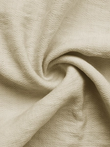 Dettaglio del tessuto beige in cotone e lino con trama naturale e caduta morbida