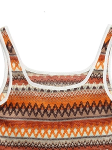 Vue détaillée de la texture tricotée bohème avec des motifs géométriques orange et marron