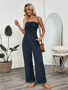 Detail of smocking texture and drawstring on navy blue strapless jumpsuit bodice