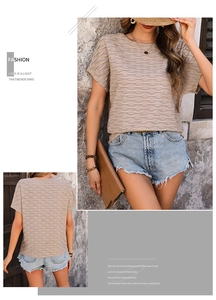 Gros plan du t-shirt abricot à manches courtes avec texture ondulée et détails du tissu