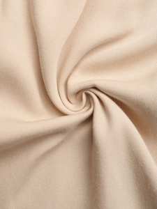 Détail rapproché de la texture du tricot beige doux avec des plis élégants