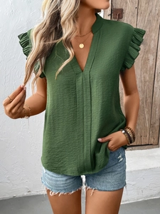 Detail of dark green V-neck top showing textured fabric and layered ruffle sleeves