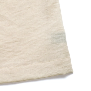 Detail view showing professional stitching and textured beige fabric on the summer dress hem