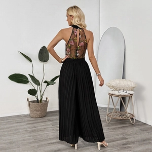 Back view of a mesh halter jumpsuit featuring floral embroidery and pleated wide legs