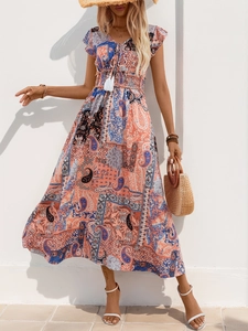 Close-up of bohemian V-neck paisley dress with tassels and smocked elastic waist detail