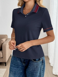 Detail of navy ribbed Polo shirt featuring red striped collar and sleeve cuffs