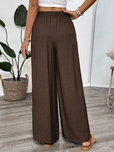 Detail view of high waist wide leg pants back design in textured brown fabric