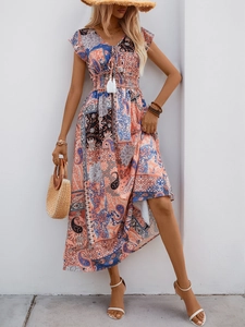Detail of V-neckline with tassels and paisley floral print on bohemian maxi dress
