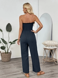 Smocked back detail of a navy blue strapless wide-leg jumpsuit with textured fabric