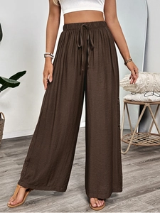 Detail of hollow embroidery on side of brown high-waisted wide leg linen trousers