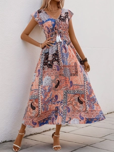 Detail of bohemian paisley print dress with V-neckline and tassel drawstring waist