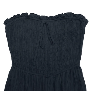 Detail of black strapless jumpsuit with textured shirred bodice and ruffled neckline bow