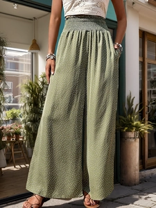 Detailed view of olive green high waisted wide leg pants with white floral print and pockets