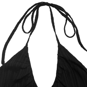 Detail of black ribbed knit halter neck dress showing V-neckline and textured fabric