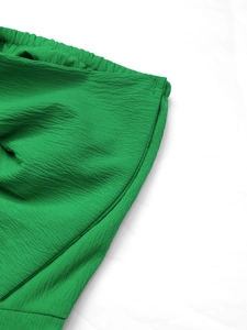 Dettaglio del tessuto testurizzato verde smeraldo con cuciture di alta qualità in vita