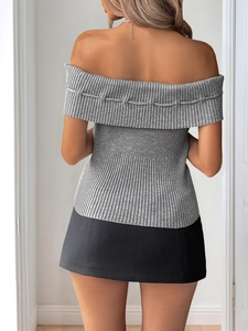 Rear view of model wearing grey ribbed off-shoulder knitted top and black mini skirt