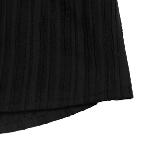 Macro detail of black textured fabric with vertical ribbed pattern and neat hem stitching