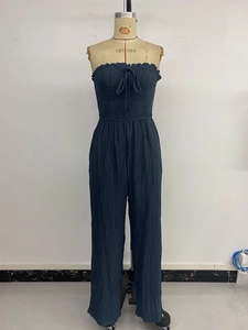 Detail of navy blue strapless jumpsuit showing elastic smocked bodice and fabric texture