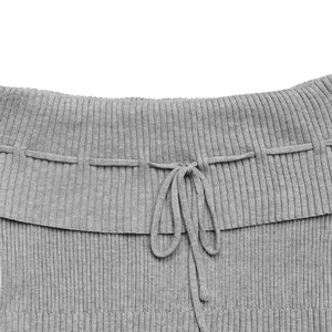 Detailed close-up of gray ribbed knit fabric with delicate drawstring bow tie design