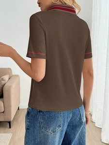 Macro shot showing the brown ribbed fabric and red striped collar details of the polo shirt
