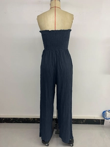 Detail of smocked elastic back and textured navy blue strapless wide leg jumpsuit