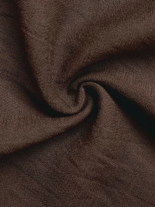 Detailed macro view of dark chocolate textile fabric with woven texture and soft drape