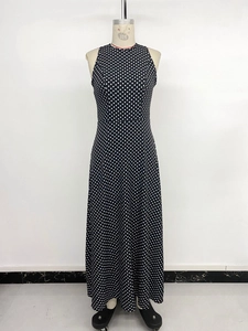 Détails d'une élégante robe longue sans manches à pois noirs et blancs avec jupe évasée