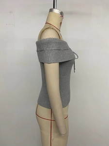 Detail view of the vertical ribbed texture and tie-up bow on grey off-shoulder knit top