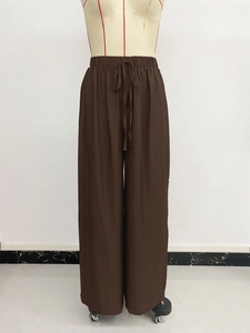 Detail view of brown wide-leg pants showing elastic waist and drawstring texture