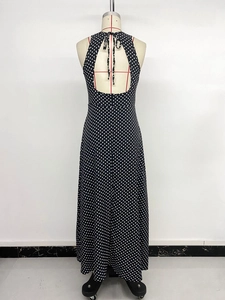 Détail d'une élégante robe longue dos nu avec pois blancs sur tissu en mousseline de soie noire