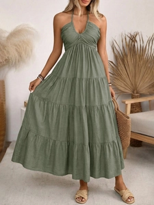 Close-up of sage green halter neck long dress with layered cake hem and backless design