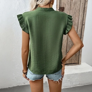 Deep green ruffle sleeve V-neck blouse for women shown in an outdoor lifestyle setting
