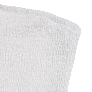 Detailed close-up of white smocking texture and elastic pleats on a strapless dress