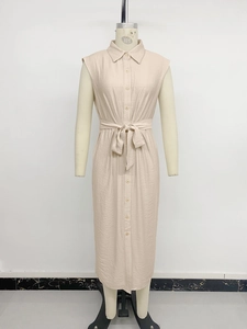 Detail of waist tie and single-breasted buttons on a beige sleeveless shirt dress