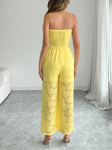 Détails du tissu jacquard floral et taille smockée au dos de la combinaison jaune